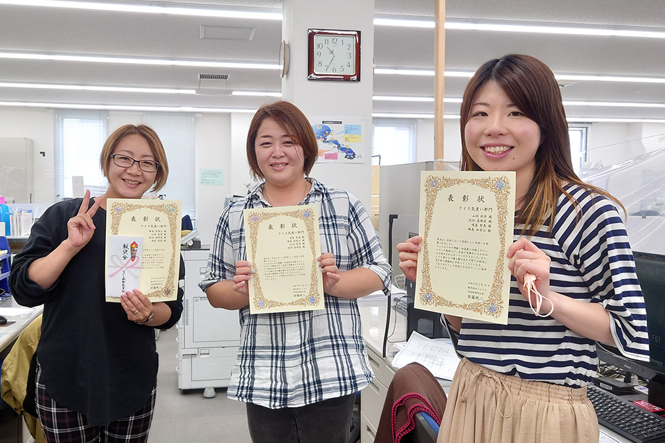 調査診断部の鳴島さん、峰島さん、山田さん、写真には不在の池田さん、グランプリおめでとうございます！